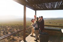 Amis seniors sur le balcon du chalet safari ensoleillé Afrique du Sud — Photo de stock