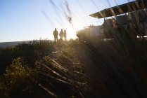 Grupo de excursão de safári de silhueta e veículo off-road na colina ao nascer do sol — Fotografia de Stock