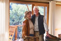 Беззаботная пожилая пара смеется в номере отеля — стоковое фото