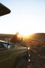 Amigos en safari disfrutando de la escénica salida del sol Sudáfrica - foto de stock