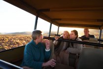 Amigos mayores montando en safari vehículo todoterreno - foto de stock