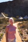 Retrato feliz mujer mayor en el sendero fuera cabañas de safari lodge - foto de stock