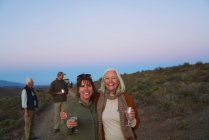 Portrait happy mature women friends on safari drinking champagne — Stock Photo