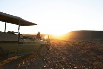 Safari groupe regardant coucher de soleil en véhicule tout-terrain Afrique du Sud — Photo de stock