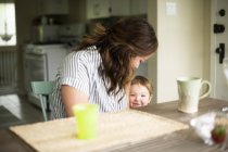 Mutter und süße Kleinkind Tochter am Küchentisch — Stockfoto