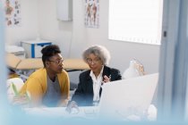 Reunião médica feminina com paciente em computador em consultório médico — Fotografia de Stock
