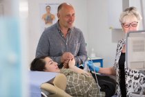 Techniker führt Ultraschall für glückliche Schwangere im Untersuchungsraum durch — Stockfoto