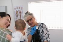 Pediatra donna che parla con madre e bambino in sala esami — Foto stock