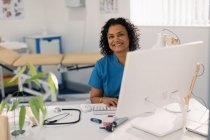 Retrato confiante médico feminino trabalhando no computador em consultório de médicos — Fotografia de Stock