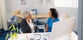 Medico donna che parla con il paziente anziano nello studio medico — Foto stock