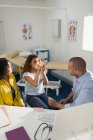 Male pediatrician teaching girl patient how to use inhaler in doctors office — Stock Photo