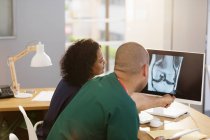 Ärzte beraten sich, untersuchen Röntgen am Computer in Arztpraxis — Stockfoto