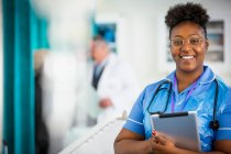Portrait infirmière confiante avec tablette numérique — Photo de stock