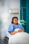Portrait fille souriante patient dans le lit d'hôpital — Photo de stock
