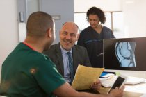 Medico e infermiere discutono di radiografia digitale al computer in clinica — Foto stock
