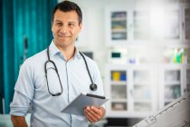 Портрет уверенный мужчина врач с цифровой таблеткой в больнице — стоковое фото