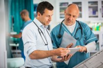 Male doctors using digital tablet in hospital — Stock Photo
