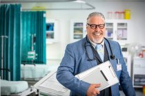 Портрет уверенный старший врач мужского пола делает обход в больнице — стоковое фото
