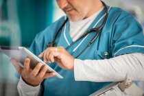 Чоловік лікар використовує цифровий планшет — стокове фото