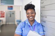 Ritratto sorridente, infermiera sicura di sé nel corridoio dell'ospedale — Foto stock