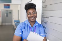 Портрет усміхненої, впевненої жінки-медсестри в лікарняному коридорі — стокове фото