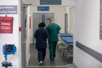 Doctor and surgeon walking in hospital corridor — Stock Photo