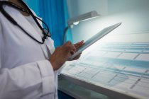 Закрийте жіночого лікаря за допомогою цифрового планшета у лікарняній палаті. — стокове фото