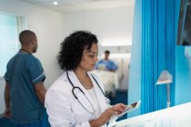 Female doctor using digital tablet in hospital room — Stock Photo