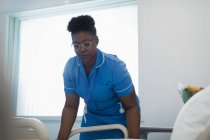 Женщина-медсестра заправляет больничную койку — стоковое фото