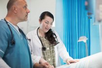 Лікарі обговорюють документи в лікарняній кімнаті — стокове фото