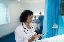 Сосредоточенная женщина-врач с помощью цифрового планшета в больничной палате — стоковое фото