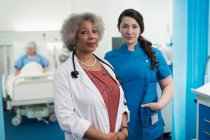 Retrato confiante médico e enfermeira no quarto do hospital — Fotografia de Stock