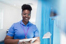 Портрет впевненої жінки-медсестри з використанням цифрового планшета в лікарняній кімнаті — стокове фото