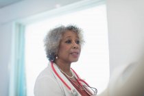 Старша жінка-лікар робить раунди, розмовляє в лікарні — стокове фото