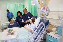 Ärzte machen Runde, sprechen mit Paar auf Krankenhausstation — Stockfoto
