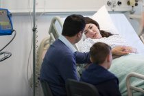 Family visiting, comforting patient in hospital room — Stock Photo