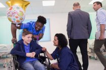 Arzt und Krankenschwester sprechen mit Patientin im Rollstuhl auf Krankenhausstation — Stockfoto