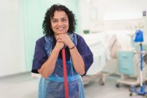 Retrato sonriente, mujer confiada limpieza ordenada sala de hospital - foto de stock