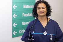 Portrait confiant femme médecin dans le couloir de l'hôpital — Photo de stock