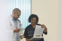 Médicos con consulta de historias clínicas en el hospital - foto de stock