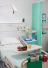 Цветы на подносе над больничной койкой в пустой палате больницы — стоковое фото