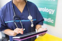 Женщина-врач с помощью цифрового планшета в больнице — стоковое фото