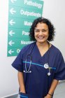 Retrato seguro, feliz médico femenino en el pasillo del hospital - foto de stock