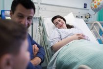 Lächelnder Patient zu Besuch bei Familie im Krankenhauszimmer — Stockfoto