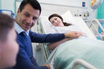 Прихильна сім'я, що відвідує пацієнта в лікарняній кімнаті — стокове фото