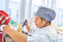 Focused young woman with Down Syndrome in baking class — Stock Photo
