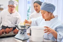 Giovane donna con sindrome di Down imparare a cuocere in cucina — Foto stock