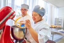 Young students with Down Syndrome using stand mixer in baking class — Stock Photo