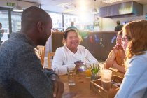 Glückliche junge Frauen mit Down-Syndrom im Café mit Freunden — Stockfoto