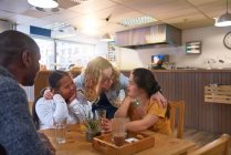 Мбаппе и молодые женщины с синдромом Дауна разговаривают в кафе — стоковое фото